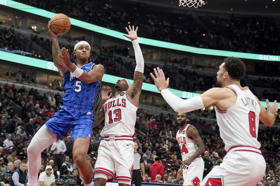 Orlando Magic's Paolo Banchero (5) passes as Chicago Bulls' Torrey Craig (13) and Zach LaVine defend during the first half of an NBA basketball game Wednesday, Nov. 15, 2023, in Chicago. (AP Photo/Charles Rex Arbogast)