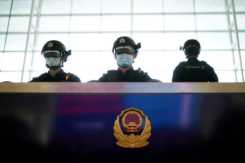 Police officers wearing face masks are seen at the Wuhan Tianhe International Airport after travel restrictions to leave Wuhan