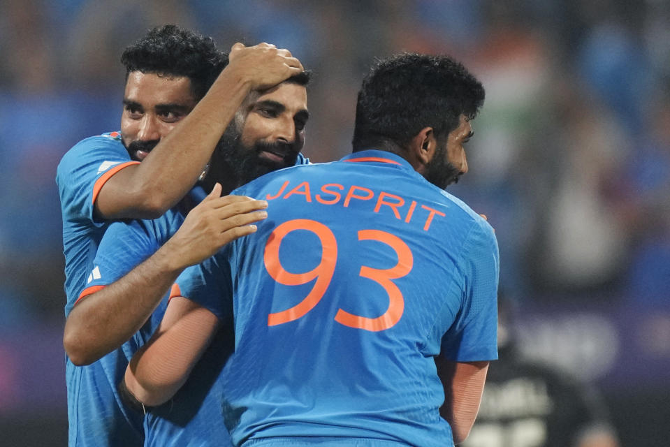India's Mohammed Shami, center, celebrates with teammates Mohammed Siraj, behind, and Jasprit Bumrah the wicket of New Zealand's Daryl Mitchell during the ICC Men's Cricket World Cup first semifinal match between India and New Zealand in Mumbai, India, Wednesday, Nov. 15, 2023. (AP Photo/Rajanish Kakade)