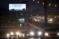 Cars drive past an electronic billboard reading "Stay home, take care of yourself and your loved ones" is displayed in an almost empty Prospect Mira (Peace's Avenue) in Moscow, Russia, Tuesday, April 7, 2020. Putin asked experts whether it would be possible to lift some of the restrictions earlier to ease the pain for the economy. They said next week would show if the lockdown has helped. The new coronavirus causes mild or moderate symptoms for most people, but for some, especially older adults and people with existing health problems, it can cause more severe illness or death. (AP Photo/Alexander Zemlianichenko)