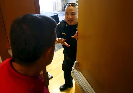 A police officer prevents an attendee from leaving the Muhammad Art Exhibit and Contest after shots were fired outside the venue in Garland, Texas May 3, 2015. REUTERS/Mike Stone