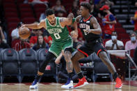 Boston Celtics forward Jayson Tatum (0) looks to drive around Houston Rockets forward Jae'Sean Tate (8) during the first half of an NBA basketball game Sunday, Oct. 24, 2021, in Houston. (AP Photo/Michael Wyke)