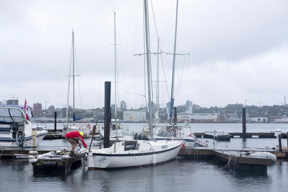 Jeffrey Mosher ties down his boat in Dartmouth, Nova Scotia. The storm is expected to bring massive swells and hurricane-force winds to the province (REUTERS)