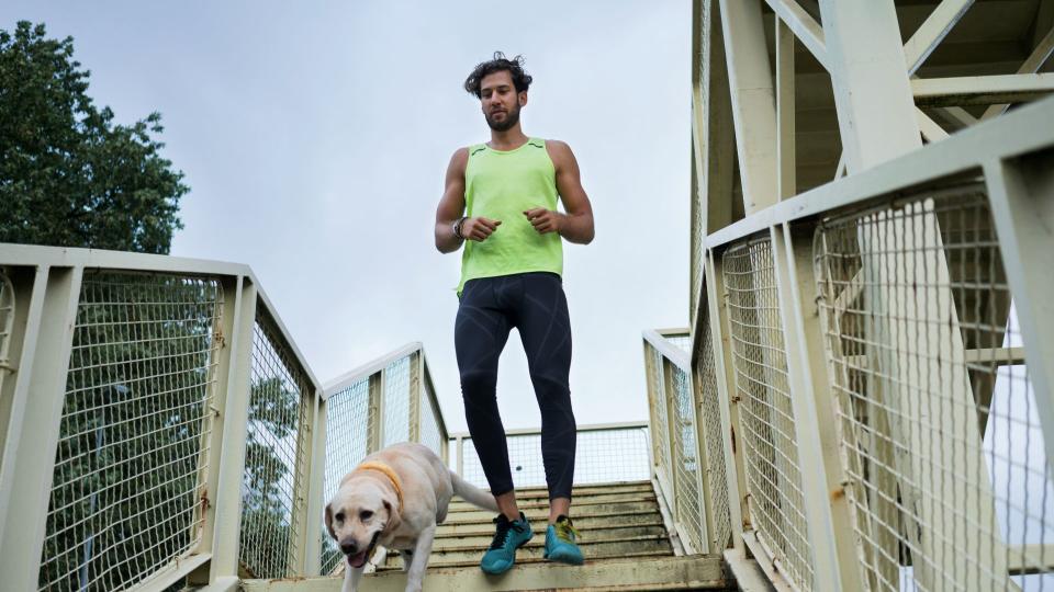 Man running downstairs with dog