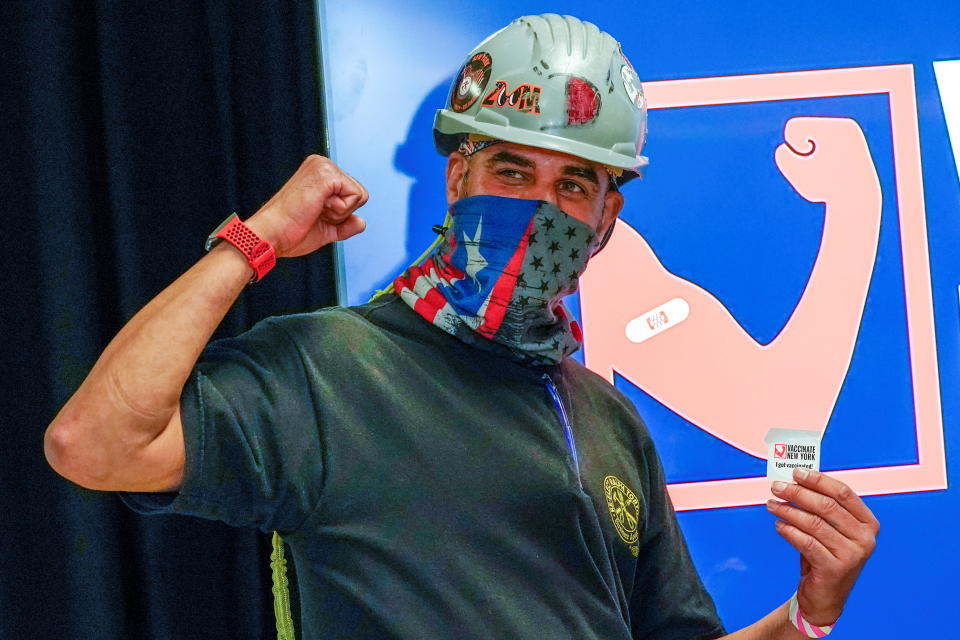 Local 28 Sheet Metal Worker Demetrius Buttelman gestures after being inoculated with the first dose of the Pfizer vaccine during a news conference, at the pop up vaccination site at Belmont Park in Elmont, New York on April 14, 2021. (Mary Altaffer/Pool via Reuters)