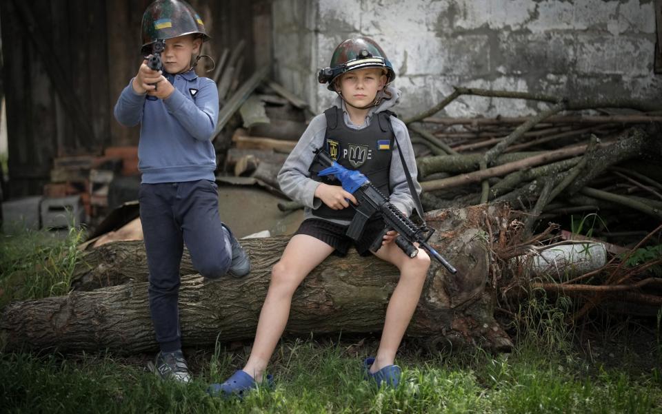 Ukrainian boys Andrii, aged 12 and his friend Valentyn 6, pose as theyplay at being soldiers and man their makeshift checkpoint in their village - Christopher Furlong/Getty Images