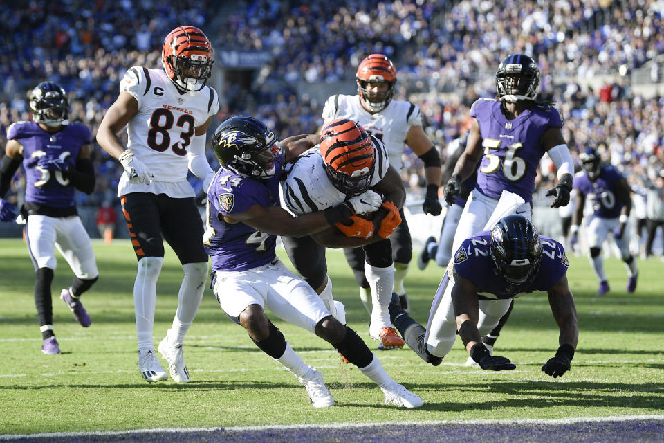 Cincinnati Bengals running back Joe Mixon, center right, runs for a touchdown as Baltimore Ravens cornerback Marlon Humphrey, center left, tries to bring him down during the second half of an NFL football game, Sunday, Oct. 24, 2021, in Baltimore. (AP Photo/Nick Wass)