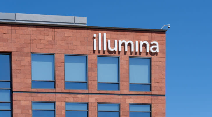 Illumina (ILMN) logo displayed on reddish stone facade building against blue sky background