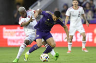 Toronto FC midfielder Deybi Flores, left, and Orlando City midfielder César Araújo compete for the ball during the first half of an MLS soccer match Saturday, April 27, 2024, in Orlando, Fla. (AP Photo/Phelan M. Ebenhack)