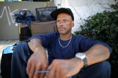 Brian Romero, 42, sits in a park where he spends time when not sleeping outside a church in Los Angeles, California, U.S. April 11, 2018. REUTERS/Lucy Nicholson