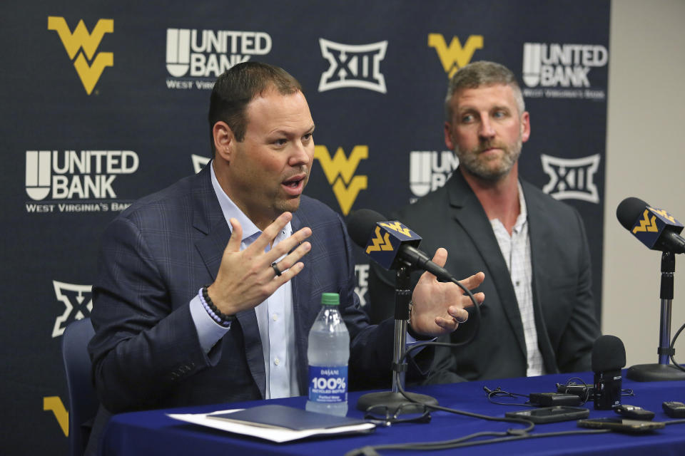 West Virginia athletic director Wren Baker, left, and interim NCAA college basketball coach Josh Eilert, right, answer questions during a news conference, Monday, June 26, 2023, in Morgantown, W.Va. (AP Photo/Kathleen Batten)