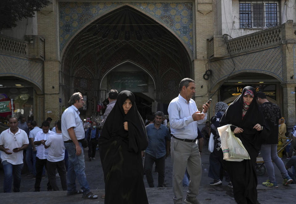 Two women walk around in the old main bazaar of Tehran with head-to-toe veiled Islamic wear, Iran, Saturday, Oct. 1, 2022. Thousands of Iranians have taken to the streets over the last two weeks to protest the death of Mahsa Amini, a 22-year-old woman who had been detained by the morality police in the capital of Tehran for allegedly wearing her mandatory Islamic veil too loosely. (AP Photo/Vahid Salemi)