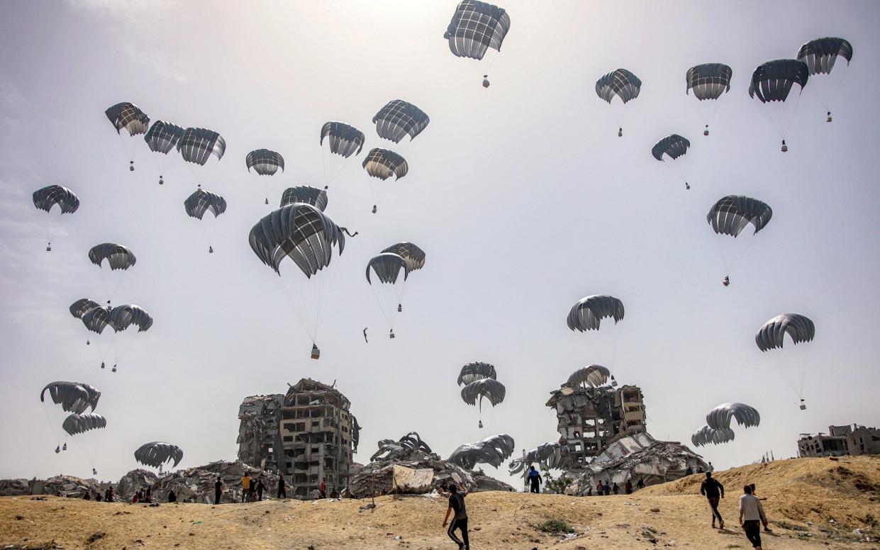 People rush to landing humanitarian aid packages dropped over the northern Gaza Strip