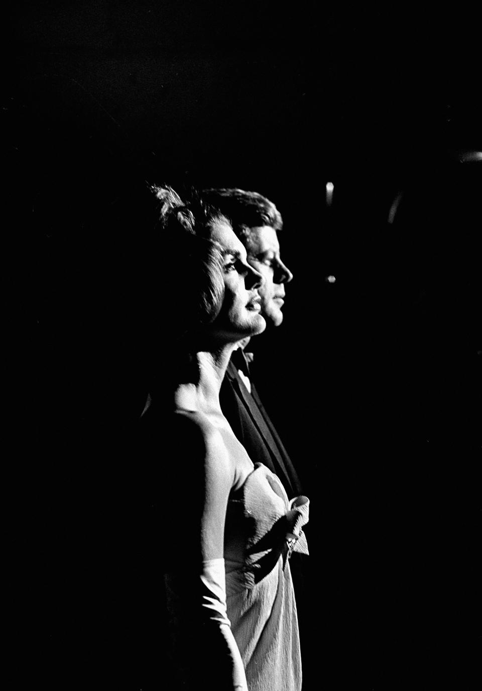 First lady Jacqueline Kennedy and President John F. Kennedy stand at attention during the playing of the national anthem at start of a reception during their state visit to Mexico City, Mexico, on June 30, 1962. (AP Photo/Henry Burroughs)