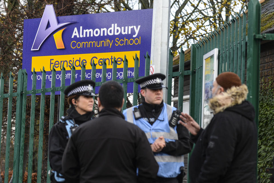 Police and members of the local community pictured outside Almondbury Community School yesterday (SWNS)