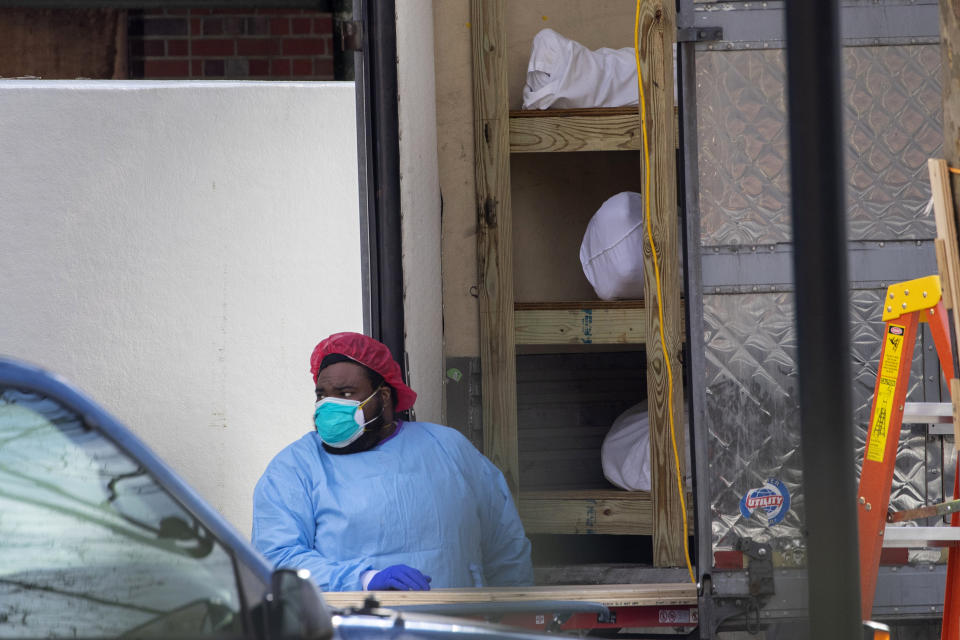 Medical personnel prepare to transport a body from a refrigerated container at Kingsbrook Jewish Medical Center, Wednesday, April 8, 2020, in the Brooklyn borough New York. From speculation that the coronavirus was created in a lab to a number of hoax cures, an overwhelming amount of false information about COVID-19 has followed the virus as it circled the globe over the past year. (AP Photo/Mary Altaffer)