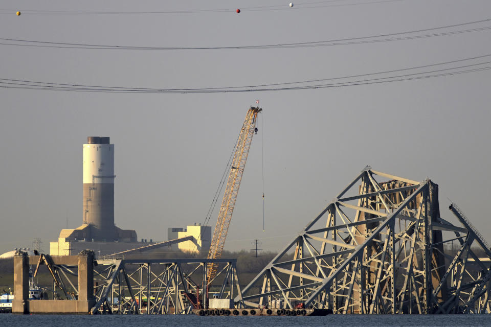 A crane is seen near the wreckage of the Francis Scott Key Bridge on Friday, March 29, 2024 in Baltimore. A cargo ship rammed into the major bridge in Baltimore early Tuesday, causing it to collapse in a matter of seconds. (AP Photo/Steve Ruark)