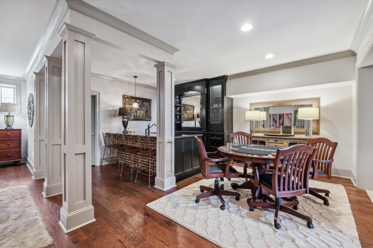 A basement with a wet bar and a pool table.