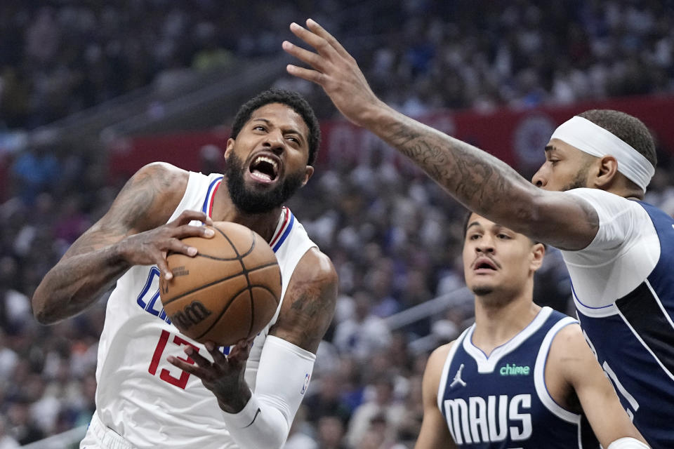 Los Angeles Clippers forward Paul George, left, tries to shoots as Dallas Mavericks guard Josh Green, center, and center Daniel Gafford defend during the first half in Game 5 of an NBA basketball first-round playoff series Wednesday, May 1, 2024, in Los Angeles. (AP Photo/Mark J. Terrill)