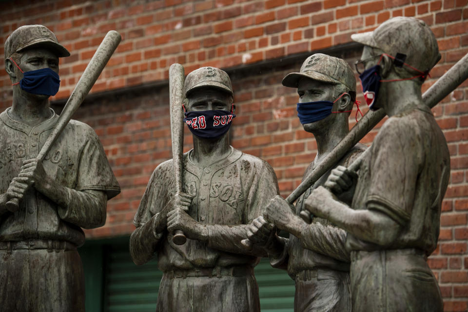 BOSTON, MA - APRIL 9: The "Teammates" statues of former Boston Red Sox players Ted Williams, Bobby Doerr, Johnny Pesky and Dom DiMaggio wear makeshift masks made of Red Sox merchandise as the Major League Baseball season is postponed due the coronavirus pandemic on April 9, 2020 at Fenway Park in Boston, Massachusetts. (Photo by Billie Weiss/Boston Red Sox/Getty Images)