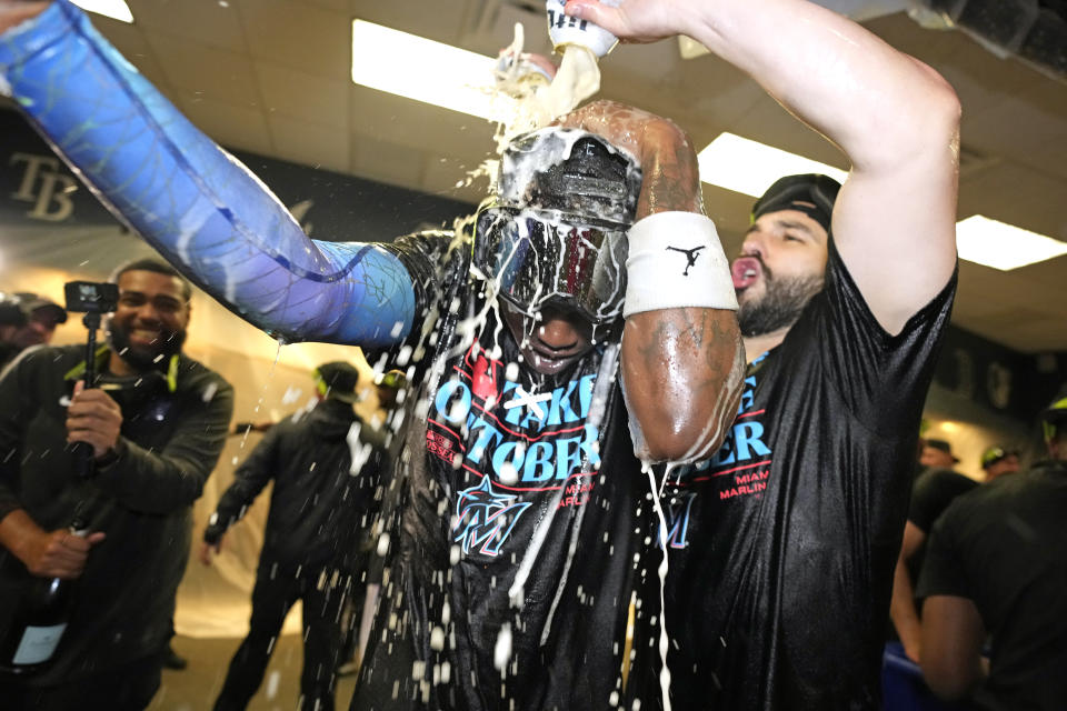 Miami Marlins' Tanner Scott, right, douses Jazz Chisholm Jr. during a locker room celebration after the Marlins clinched a wild-card spot with a 7-3 win over the Pittsburgh Pirates in a baseball game in Pittsburgh, Saturday, Sept. 30, 2023. (AP Photo/Gene J. Puskar)