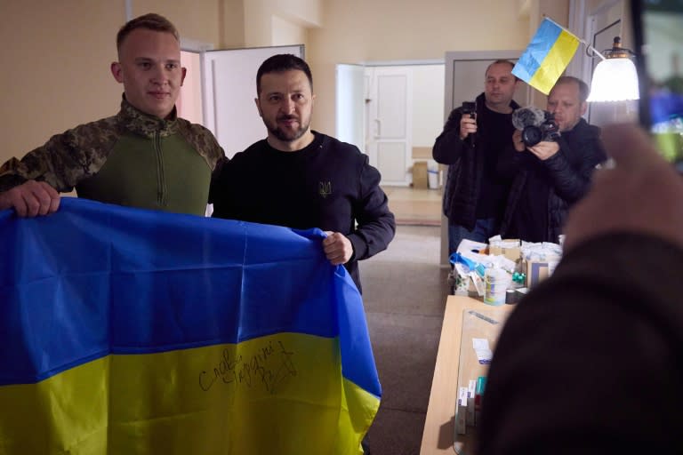 Photo fournie par la présidence ukrainienne montrant le président Volodymyr Zelensky (C) poser avec un soldat lors d'une visite aux troupes dans la région de Donetsk, dans l'est de l'Ukraine, le 19 avril 2024 (Handout)