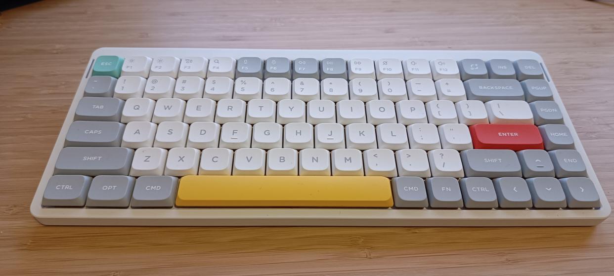  A white NuPhy Air75 V2 keyboard on a wooden desk. 