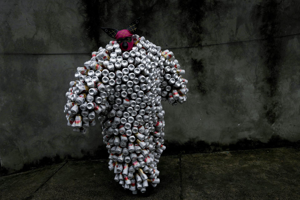 Un asistente con un disfraz hecho de latas de cerveza y refrescos en el desfile de Carnaval Bloco da Latinha en Madre de Deus, Brasil, el domingo 11 de febrero de 2024. (AP Foto/Eraldo Peres)