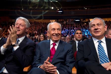 Israeli President Shimon Peres (C) sits next to former U.S. President Bill Clinton (L) and Israeli Prime Minister Benjamin Netanyahu (R) during celebrations marking Peres' 90th birthday in Jerusalem in this June 18, 2013 file photo. REUTERS/Jim Hollander/Pool/Files
