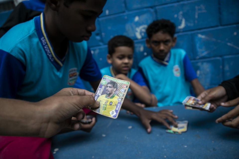 Un grupo de estudiantes juega con estampas del Mundial en Sao Goncalo, la ciudad donde nación Vinícius Júnior, el lunes 7 de noviembre de 2022 (AP Foto/Bruna Prado)