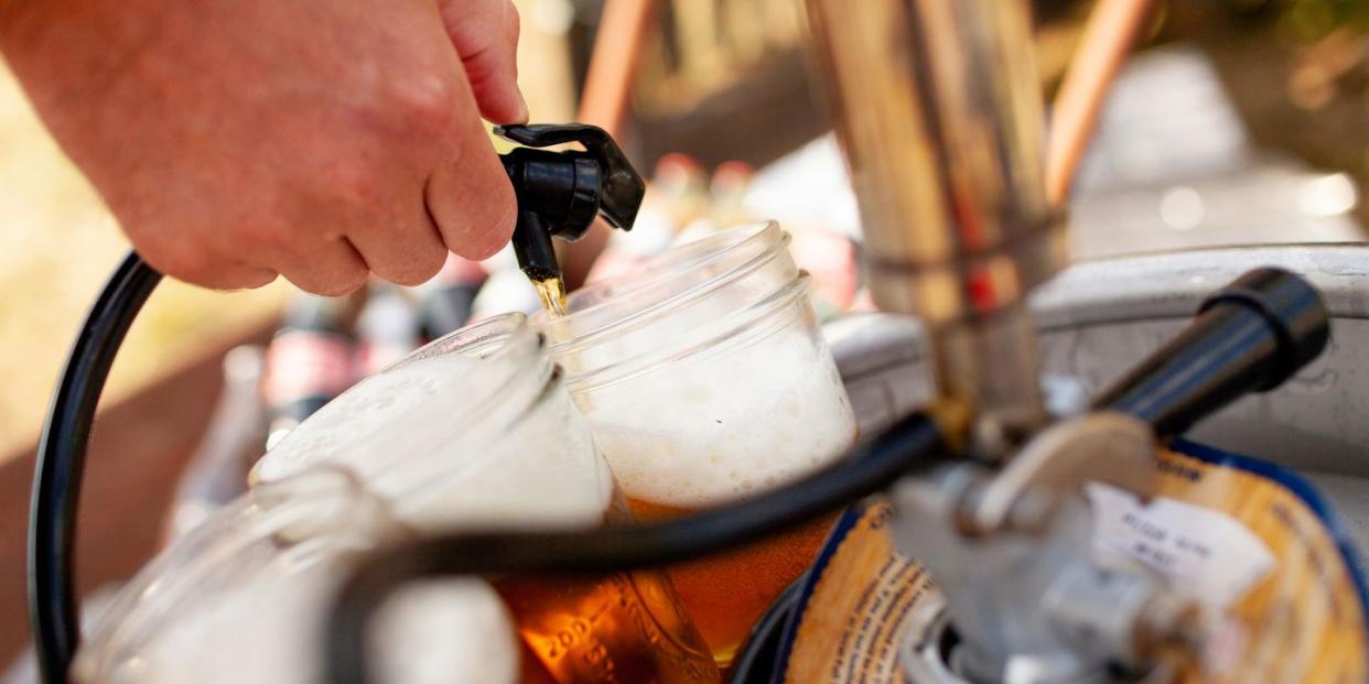 beer being pourn into mason jar from keg