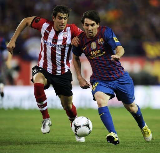 Athletic Bilbao's defender Borja Ekiza (L) clashes with Barcelona's forward Lionel Messi during the Spanish King's Cup final football match at the Vicente Calderon stadium, in Madrid. Barcelona won 3-0