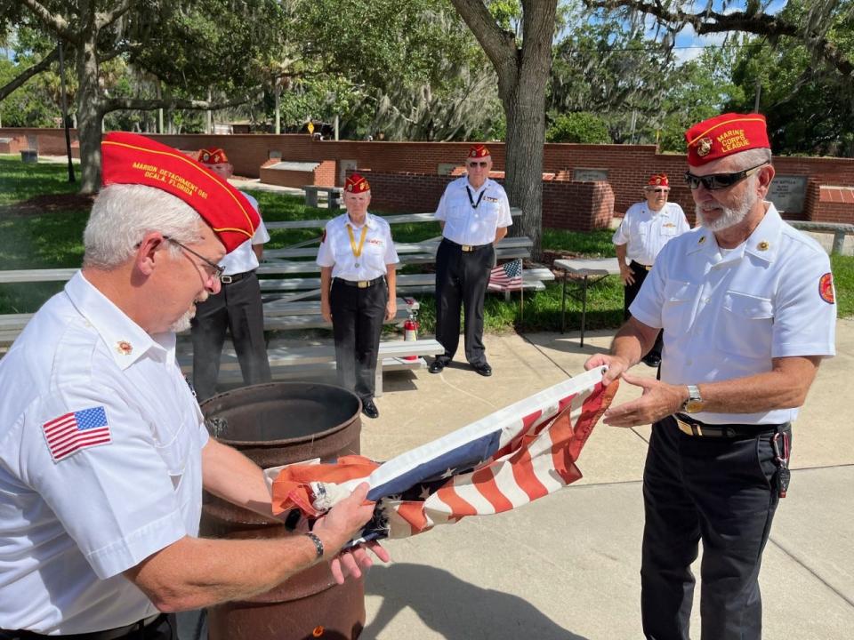 Members of Marine Corps League 061 of Ocala prepare a no-longer-serviceable American flag for burning during a flag retirement ceremony at the 14th annual MCVC Flag Day Essay and Flag Retirement event on Sunday at the Ocala-Marion County Veterans Memorial Park.