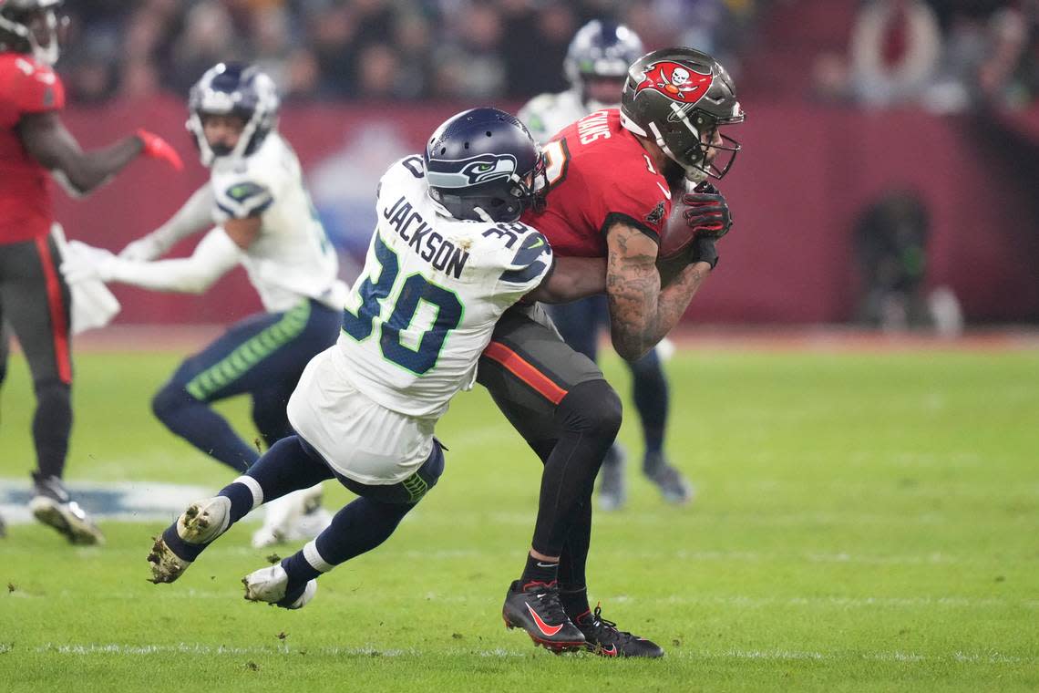 Tampa Bay Buccaneers’ Mike Evans (13) is tackled by Seattle Seahawks’ Mike Jackson during the second half of an NFL football game, Sunday, Nov. 13, 2022, in Munich, Germany. (AP Photo/Matthias Schrader)