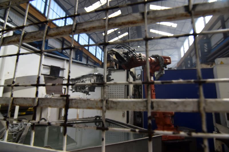 A robot at Evtec Aluminium Ltd gets ready to dip a freshly-made aluminium part in a cooling tank at the company's foundry, in Kidderminster