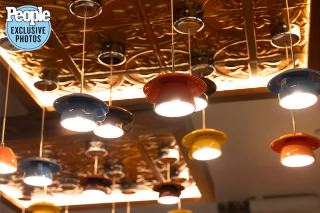 <p>Brian Nevins</p> Cups and saucer lights hang from the ceiling at Central Perk Coffeehouse in Boston.