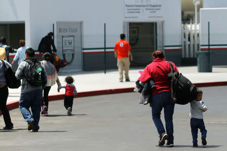 Migrants walk to enter the United States border and customs facility to apply for asylum, in Tijuana, Mexico June 19, 2018. Picture taken June 19, 2018. REUTERS/Jorge Duenes