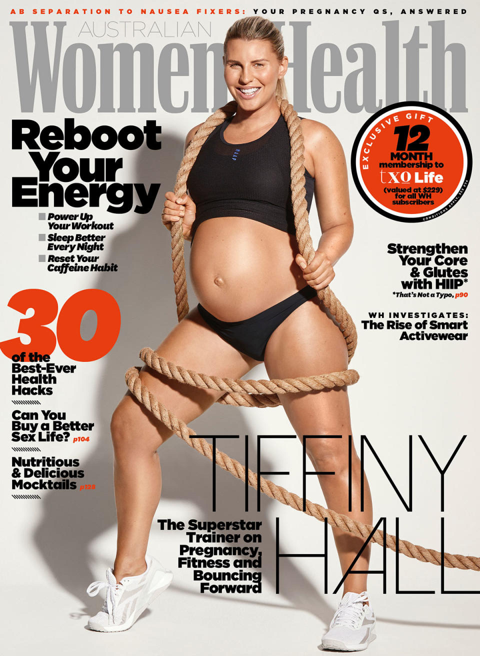 Tiffiny Hall on the cover of Women's Health, wearing a black workout bra and underwear, holding a rope. She is heavily pregnant.