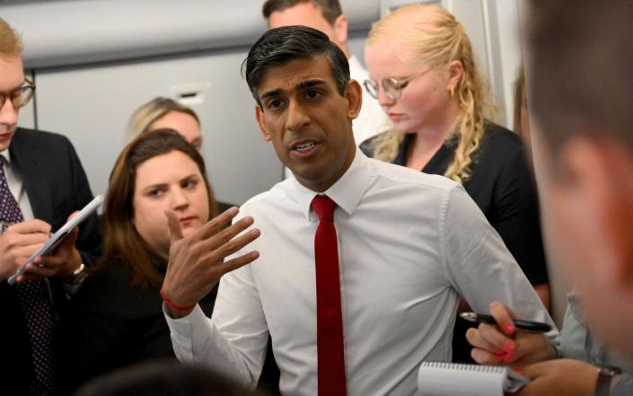 El primer ministro británico, Rishi Sunak, habla con los periodistas en su avión durante su vuelo de Londres a Vilnius, Lituania.