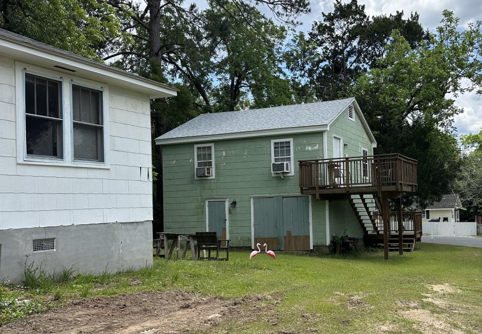 The second floor of the green building is an 'accessory dwelling unit, a one-bedroom apartment that is an accessory to the main property (which is the white house to the left and the garage below the unit. This property is located in Midtown, Tallahassee.