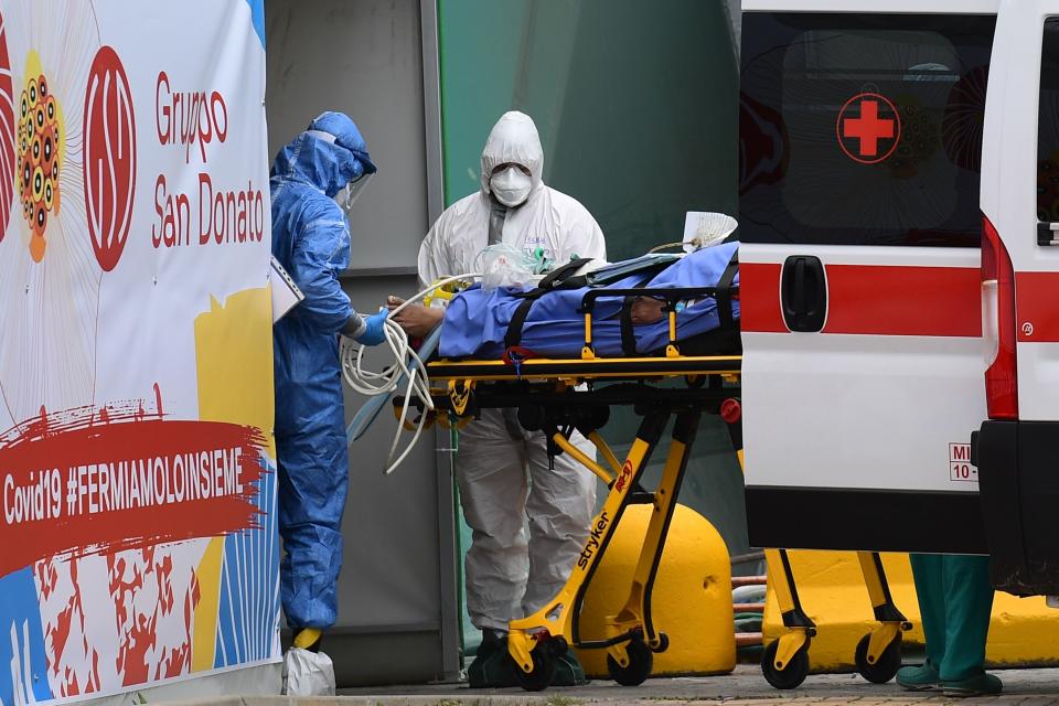 Medical workers stretch a patient from an Italian Red Cross ambulance into an intensive care unit set up in a sports center outside the San Raffaele hospital in Milan, during the COVID-19 new coronavirus pandemic. (Photo by Miguel MEDINA / AFP) (Photo by MIGUEL MEDINA/AFP via Getty Images)