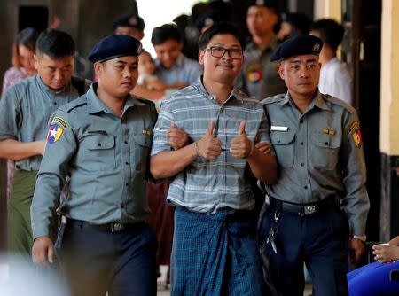 Detained Reuters journalist Wa Lone (C) is escorted by police as he arrives for a court hearing in Yangon, Myanmar May 9, 2018. REUTERS/Stringer