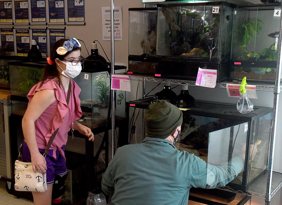 Julianna Basi, 14, an eighth grader at Jefferson Middle School, helps Erik Slatinsky, a paraprofessional at Jefferson Middle School, feed and provide water to animals on Friday at the school’s zoo.