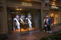 Two women walk past a Fendi boutique closed due to sanctions in the GUM department store in Moscow, Russia, Tuesday, Aug. 9, 2022. Often, it's hard to tell when stores are closed. At the famous GUM department store lined with shops in Red Square, most of the closed storefronts still had the lights on and a clerk or guard inside. (AP Photo/Alexander Zemlianichenko)