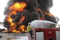 A Palestinian firefighter works during efforts to extinguish a fire at Gaza's main power plant, which witnesses said was hit in Israeli shelling, in the central Gaza Strip July 29, 2014. REUTERS/Ahmed Zakot