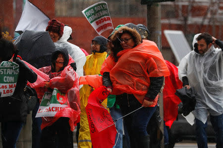 People fight with wind and rain as some of the more than 30,000 striking teachers in the Los Angeles public school system march after holding a rally at the City Hall in Los Angeles, California, U.S., January 14, 2019. REUTERS/Mike Blake