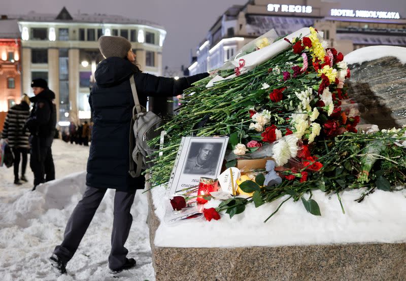 People gather at the monument to the victims of political repressions following the death of Alexei Navalny in Moscow