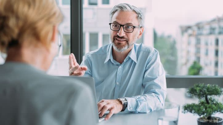 Partners of a financial advisory firm meet to discuss client retention, including new ways the firm can stay in touch with clients.