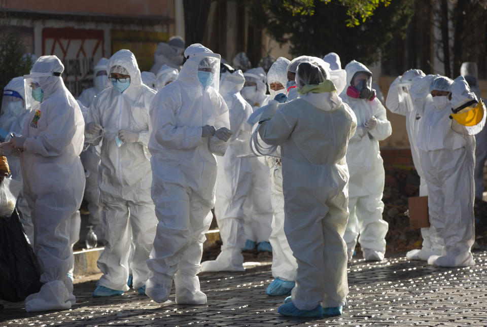 Dressed in full protective gear, doctors prepare for a house-to-house new coronavirus testing campaign, in the Villa Jaime Paz Zamora neighborhood of El Alto, Bolivia, Saturday, July 4, 2020. (AP Photo/Juan Karita)