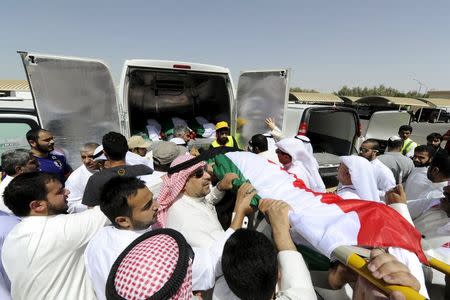 Bodies of victims of the Friday bombing are transferred to vehicles to be transported to Karbala, Iraq, at Al Jafariya cemetery in Suleibikhat, Kuwait June 27, 2015. REUTERS/Stringer